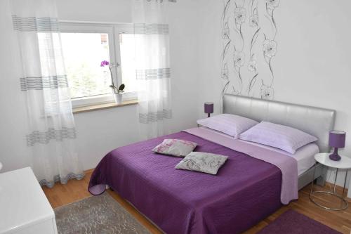 - une chambre avec un lit violet et une couverture violette dans l'établissement Apartments Ruzica, à Pula