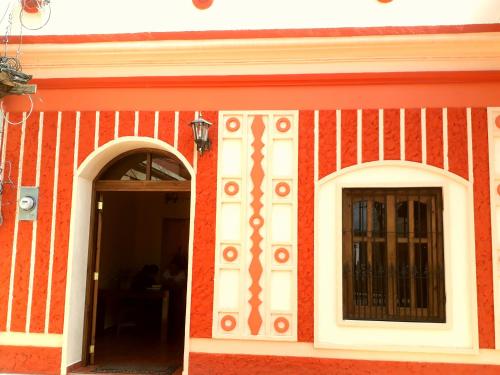 a red and white building with two windows at Posada Papa Chepe in La Esperanza
