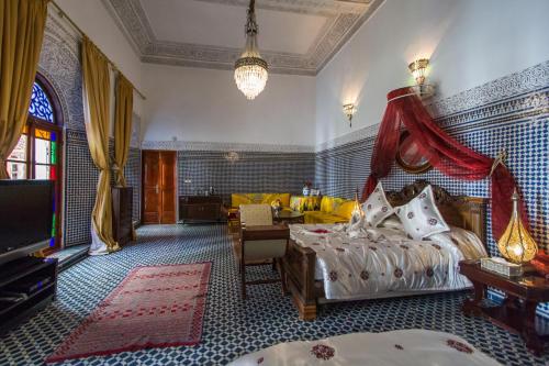 Riad Damia Suite &Spa في فاس: غرفة نوم بسرير مع مظلة