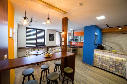a kitchen with a large wooden counter and stools at DREAM Hostel Poltava in Poltava
