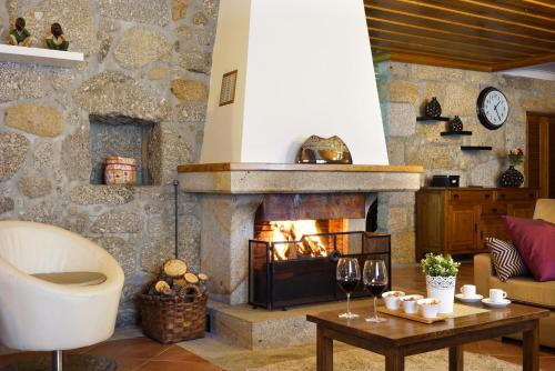 a living room with a fireplace and a table with wine glasses at Casa da Torre in Pico