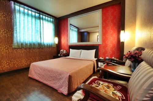 a hotel room with a bed and a mirror at Hotel Lee-Chan in Taipei