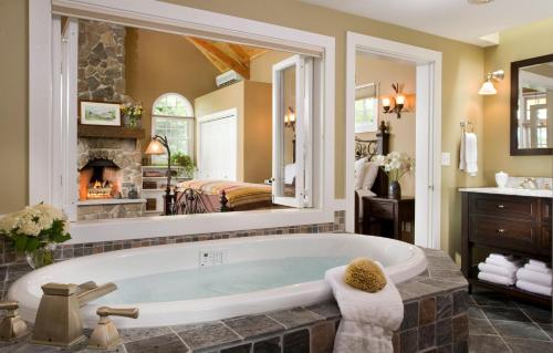 a large bathroom with a tub and a fireplace at Sugar Hill Inn in Sugar Hill