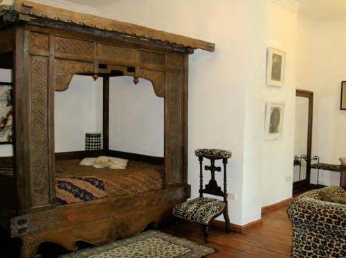 a bedroom with a canopy bed and a chair at Residenz Villa Kult in Berlin