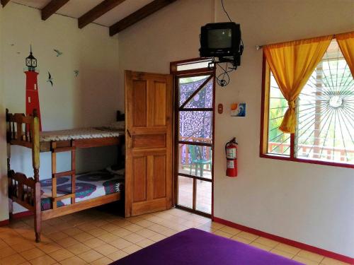 a room with two bunk beds and a television at Cabinas Caribe Luna in Cahuita