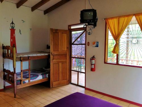 Zimmer mit 2 Etagenbetten und einem TV in der Unterkunft Cabinas Caribe Luna in Cahuita