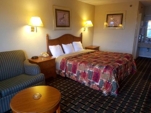 a hotel room with a bed and a couch at Americas Best Value Inn-Winnsboro in Winnsboro