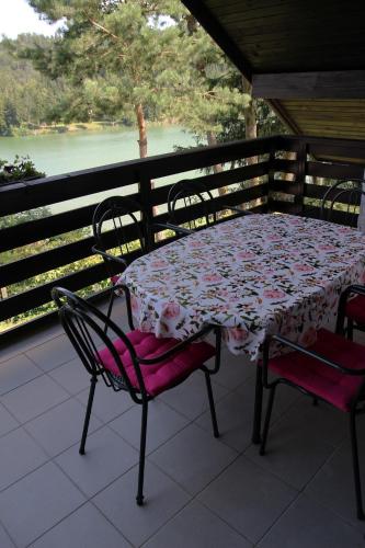 a table and chairs on a balcony with a view of a river at Lake House Apartment in Medvode