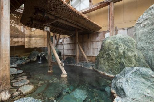 a pool of water in a building with rocks at Awara Grand Hotel in Awara