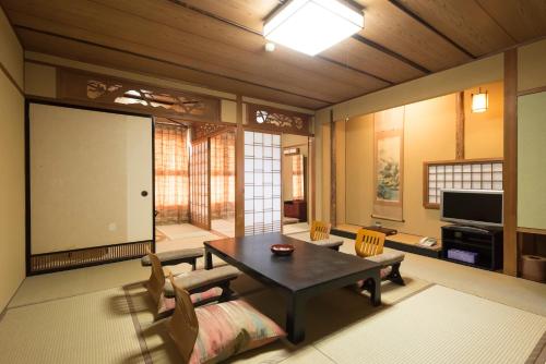 a living room with a table and a large screen at Awara Grand Hotel in Awara
