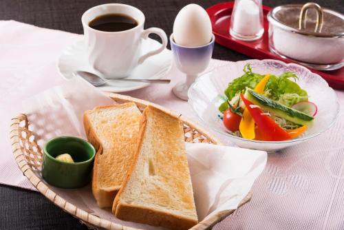 a basket with sandwiches and a salad and a cup of coffee at Awara Grand Hotel in Awara