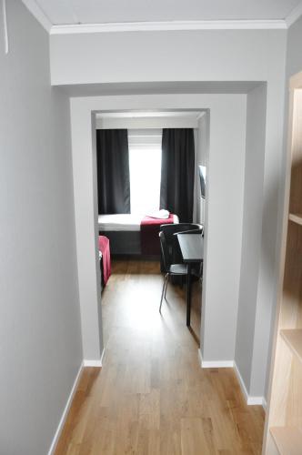 a hallway with a desk and a room with a window at City Hotel in Kristinehamn