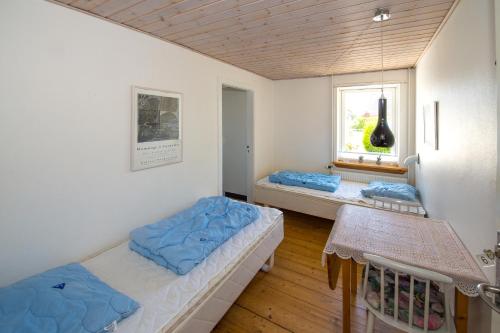 Læsø的住宿－Annekset Vesterø Havn，客房设有两张床和窗户。