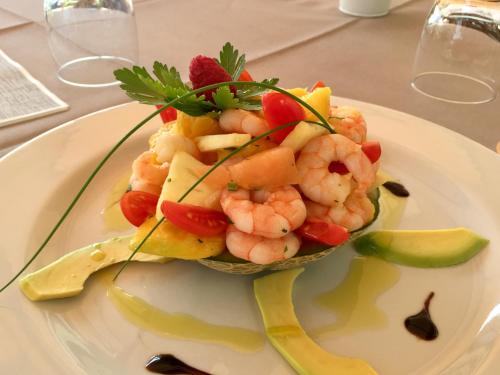 a plate of shrimp and vegetables on a table at Hotel Concordia in Porlezza