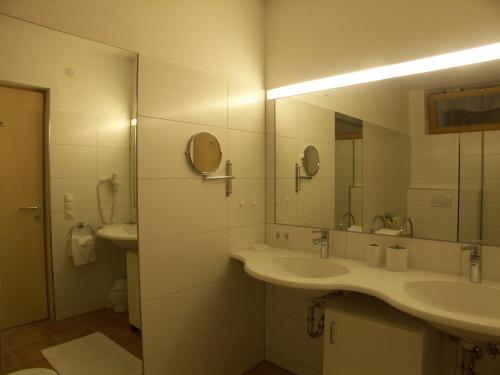 ein weißes Badezimmer mit zwei Waschbecken und einem Spiegel in der Unterkunft Appart Saroja-Tannleger in Brand