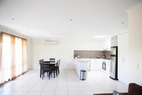 a white kitchen with a table and chairs in it at Echuca Moama Holiday Villas in Moama