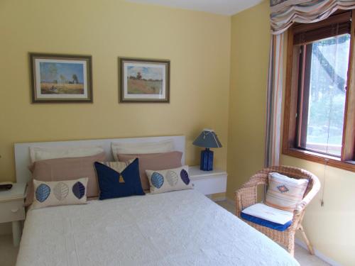 a bedroom with a bed and a chair and a window at End of the road B & B in Cranbrook
