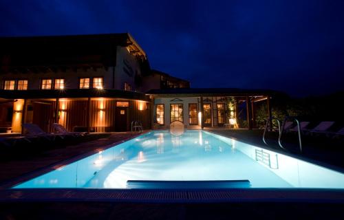 a swimming pool lit up at night at Hotel Krimmlerfälle in Krimml