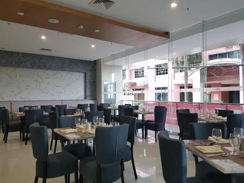 ein Restaurant mit Tischen und Stühlen und einem großen Fenster in der Unterkunft Mezzo Hotel in Cebu City