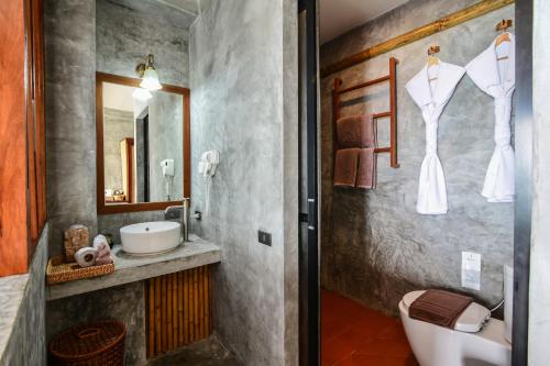 a bathroom with a sink and a toilet and a mirror at Sai Daeng Resort in Koh Tao