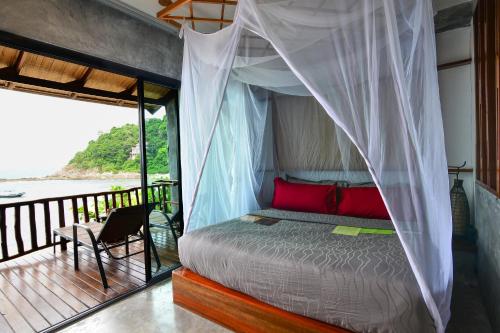 a bedroom with a canopy bed and a balcony at Sai Daeng Resort in Koh Tao