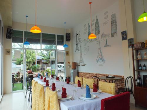 a dining room with a long table with red napkins at Avalon Residence in Savannakhet