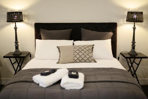 a bed with two towels on it with two lamps at Clement House in Benalla