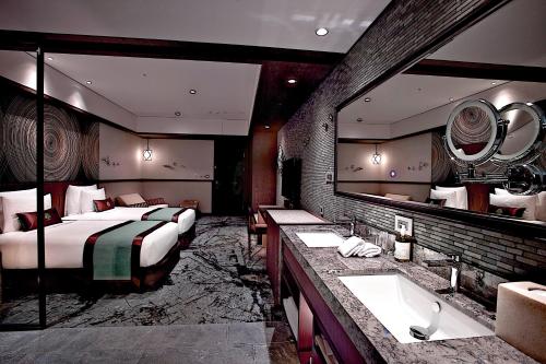 a hotel room with two beds and a large mirror at arTree hotel in Taipei