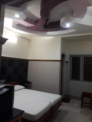 a room with a white bed and a ceiling at Krishna Lodge in Tiruchchirāppalli