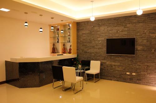馬公市的住宿－達日好民宿 ，砖墙上的带桌子和电视的用餐室