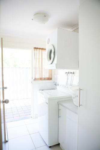a white kitchen with a sink and a window at Echuca Moama Holiday Villas in Moama