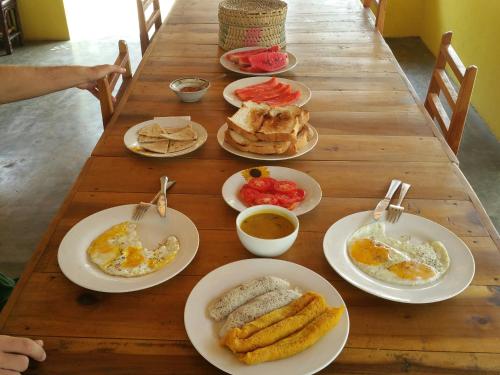 un tavolo in legno con piatti per la colazione di Salt Bay Kite and Dive Resort a Kalpitiya