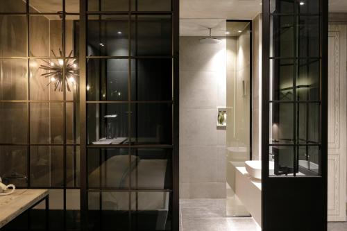 baño con armario de cristal con lavamanos en Ischia Hotel en Yongin