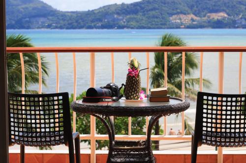 a table on a balcony with a view of the ocean at Baan Boa Resort in Patong Beach