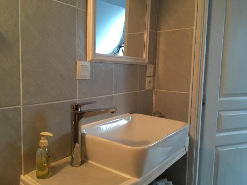 a white sink in a bathroom with a window at Le Saint Aubin- Maison d hôtes dans ce monastère du 16 siècle in Amfreville-la-Campagne