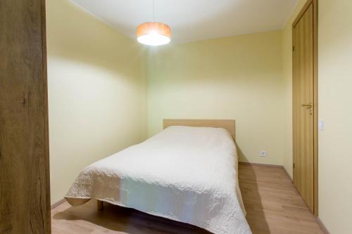 a small bedroom with a bed and a light at Pärnu Villa Harmony in Pärnu