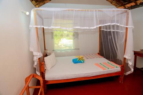 Cama pequeña en habitación con ventana en Natural Cabanas, en Tangalle