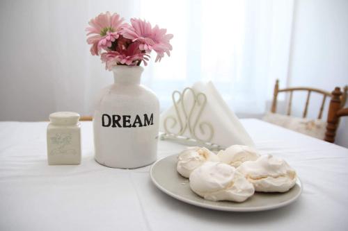 a plate of frosted donuts and a vase with flowers at Vánkos in Badacsonyörs