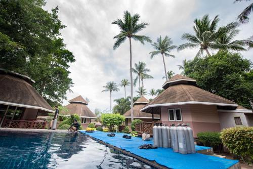 a resort with a swimming pool and palm trees at Koh Tao Coral Grand Resort in Ko Tao