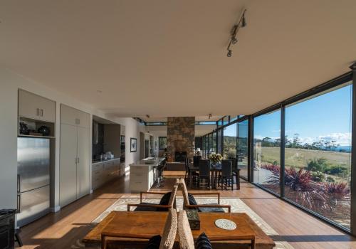 an open kitchen and dining room with floor to ceiling windows at Dragonfly Lodge in Swansea