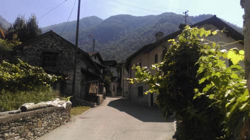 an alley with buildings and mountains in the background at Cà di Noni in Gordevio