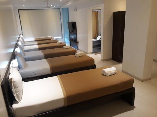 a row of beds in a hotel room at Hotel Golden View in Shirdi