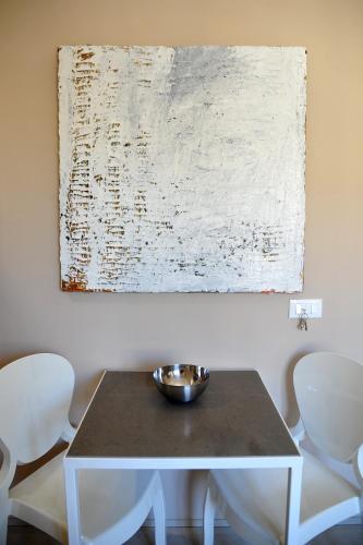 a white table with a bowl on it next to two chairs at Kalote' On The Roof Apartments in Noto