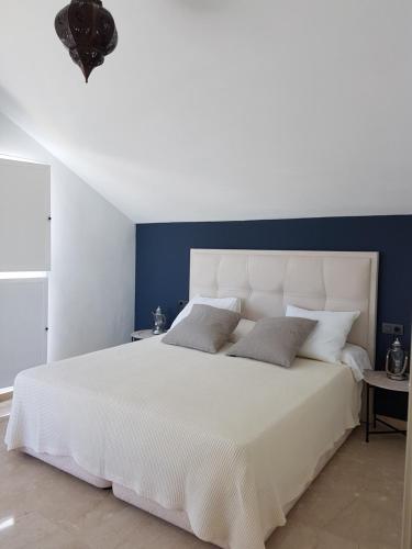 マルベーリャにあるApartment Duplex Las Arenasのベッドルーム1室(青い壁の白いベッド1台付)