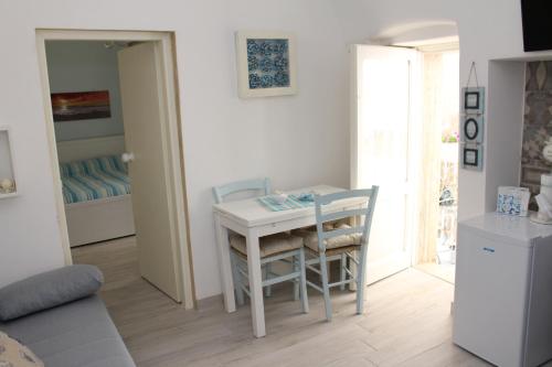 a small white table and chairs in a room at Casetta Azzurra in Monopoli