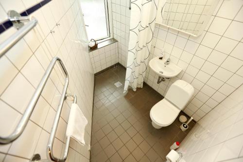 Hotel 9 små hjem في كوبنهاغن: حمام ابيض مع مرحاض ومغسلة