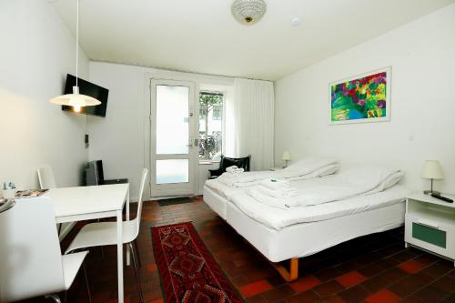 a white room with two beds and a desk at Hotel 9 små hjem in Copenhagen