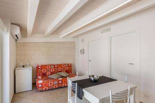 uma cozinha com uma mesa e uma cadeira num quarto em Marinella di Montalbano em Punta Secca