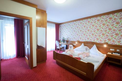 una camera d'albergo con due bambini sdraiati su un letto di Hotel Silvia a Sankt Kanzian