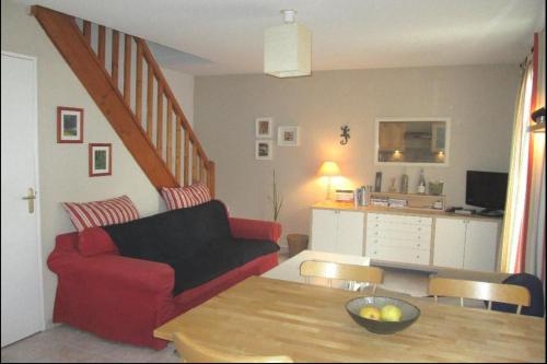 un salon avec un canapé rouge et une table dans l'établissement Aigues-Mortes villa prés des remparts, à Aigues-Mortes